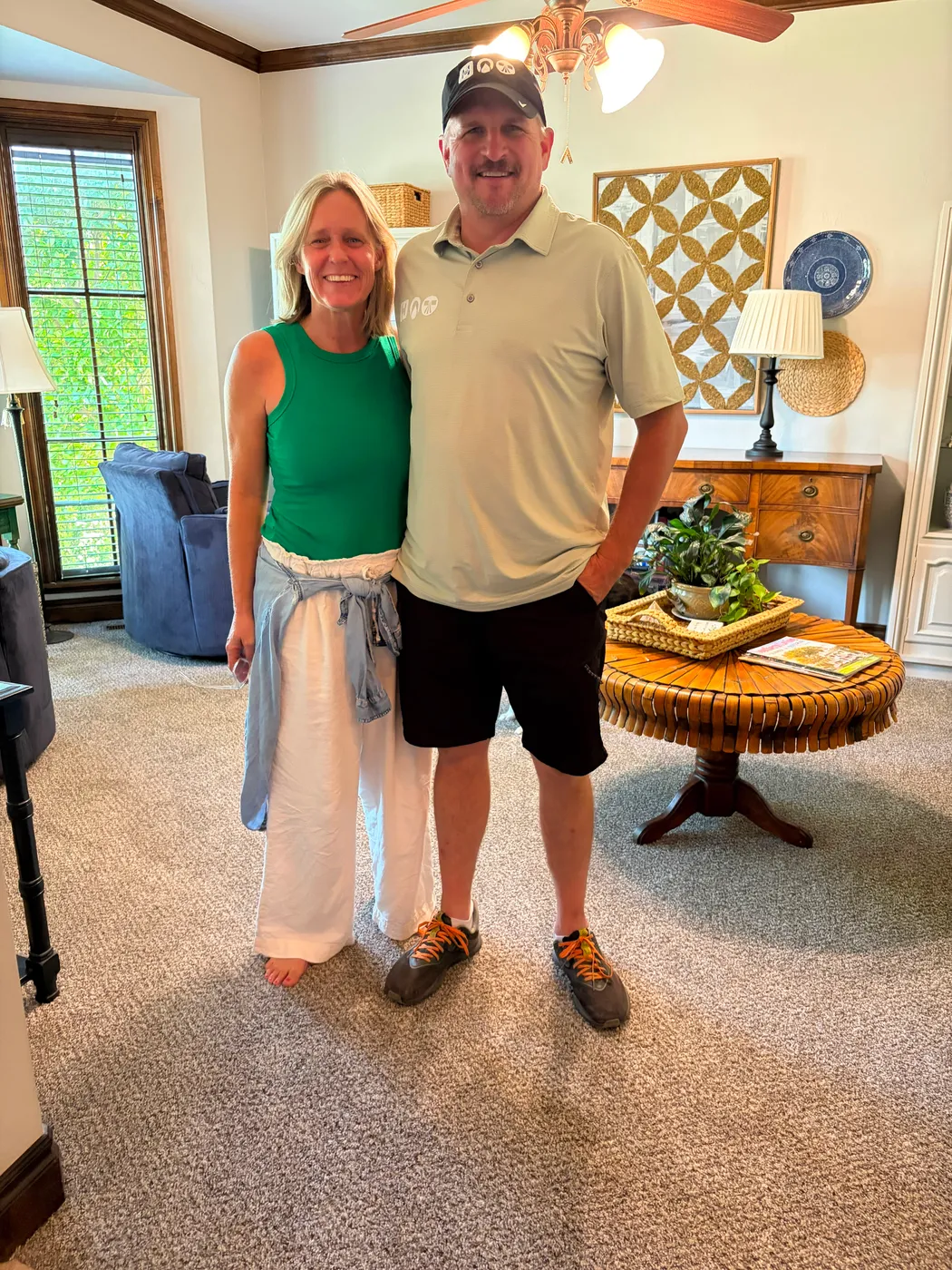 Happy Oklahoma City homeowners standing in their living room on brand-new carpet installed by Floors To You OKC
