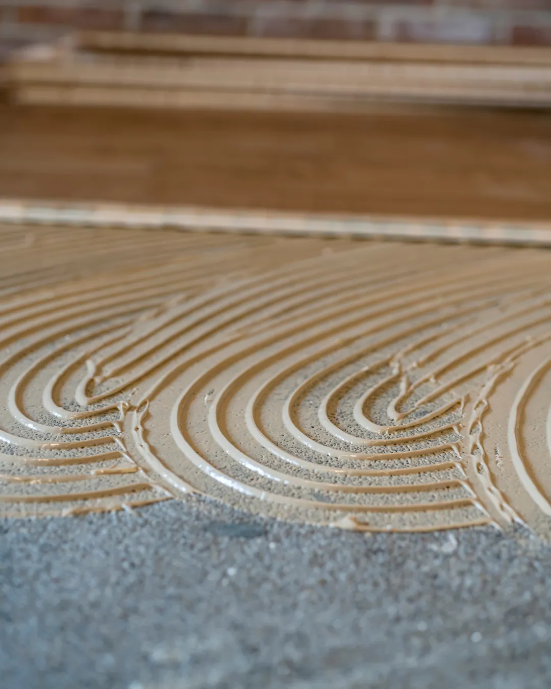 Floors To You OKC installer troweling adhesive for a glue-down vinyl install